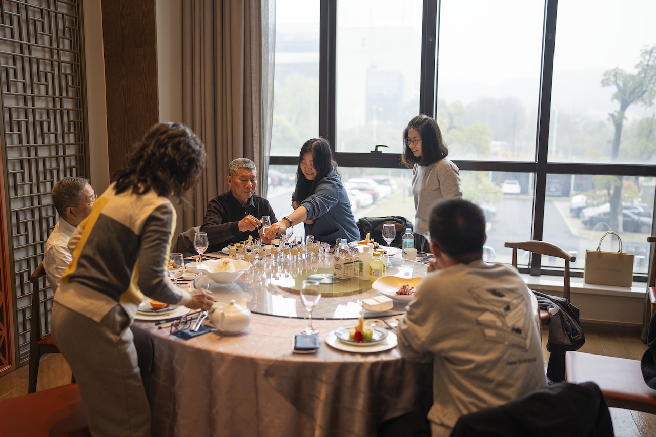 Family and friends gathered around a table, sharing small pours of kiwi spirit.